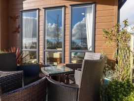 An outdoor seating area with a table and chairs near windows at FW4 (Fairways 4)
