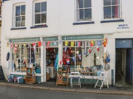 A storefront displaying goods and seating at Fowey River Trading in Doublebois near Dobwalls