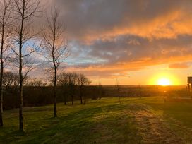 A sunset scene with trees and a house at FW4 (Fairways 4) Doublebois near Dobwalls