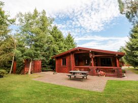 A log cabin with a table and bench in front at Little Bears Hideaway @ 23 Lakeside, Felmoor Park near Felton