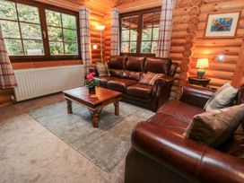 A living room with leather sofas and a wooden table at Little Bears Hideaway @ 23 Lakeside Felmoor Park near Felton