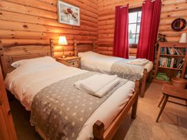 A bedroom with twin beds and a wooden bookshelf at Little Bears Hideaway @ 23 Lakeside Felmoor Park near Felton