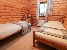 A bedroom with twin beds and a bedside table at Little Bears Hideaway @ 23 Lakeside Felmoor Park near Felton