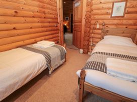A bedroom with two beds and wooden walls at Little Bears Hideaway @ 23 Lakeside Felmoor Park near Felton