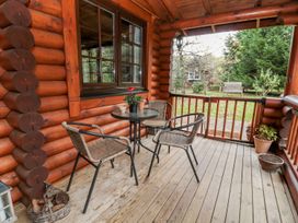 An outdoor porch with a table and chairs at Little Bears Hideaway @ 23 Lakeside in Felmoor Park near Felton