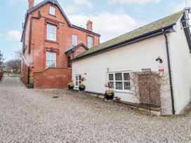 An outdoor view of The Stables in Prestatyn with a gravel driveway and nearby buildings