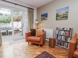 A living room with an armchair and bookshelf at The Stables in Prestatyn