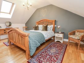 A bedroom with a bed and a desk with a mirror at The Stables in Prestatyn