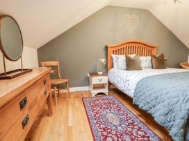 A bedroom with a bed and dresser at The Stables in Prestatyn