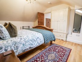 A bedroom with a bed and wardrobe at The Stables in Prestatyn