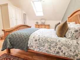 A bedroom with a bed and a dresser at The Stables in Prestatyn