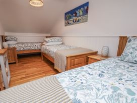 A bedroom with two beds and a painting on the wall at The Stables in Prestatyn
