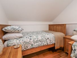 A bedroom with a bed and side table at The Stables in Prestatyn