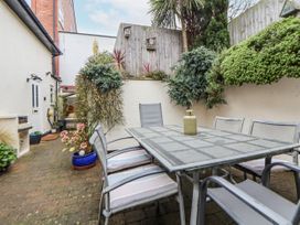 A garden with a table and chairs surrounded by plants at The Stables in Prestatyn
