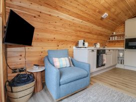 A living room with an armchair and kitchen units at Park View Lodge in 