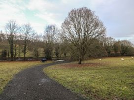 A path leading through a field with trees and sheep at Park View Lodge 