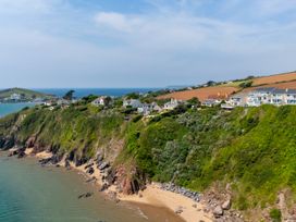 A scenic view of houses on a cliff by the ocean at 6 Avon Quillet Bigbury-On-Sea
