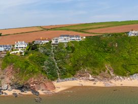 A coastal view with houses on a cliff at 6 Avon Quillet, Bigbury-On-Sea