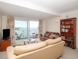 A living room with a view of the sea and furniture at 6 Avon Quillet in Bigbury-On-Sea