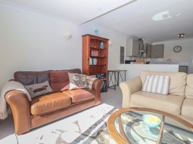 A living room with a sofa and bookshelf at 6 Avon Quillet Bigbury-On-Sea