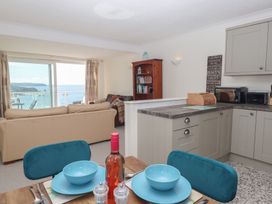 A living room with a dining area and kitchen at 6 Avon Quillet in Bigbury-On-Sea
