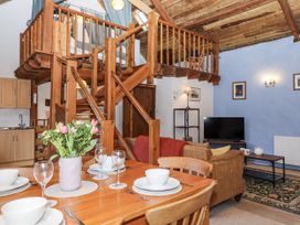A living room with a staircase and kitchen area at Swallows Nest in Widecombe-in-the-Moor near Postbridge