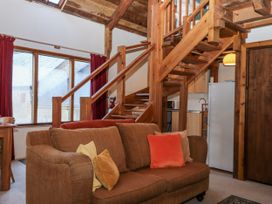 A living room with a sofa and stairs at Swallows Nest in Widecombe-in-the-Moor near Postbridge
