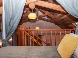 A loft with a bed and railing at Swallows Nest in Widecombe-in-the-Moor near Postbridge