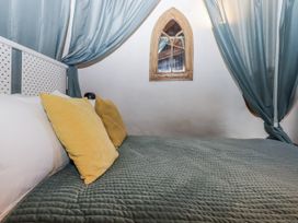 A bed with yellow pillows and curtains in a room at Swallows Nest Widecombe-in-the-Moor near Postbridge