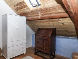 An attic with a white wardrobe and a wooden chest of drawers at Swallows Nest Widecombe-in-the-Moor near Postbridge