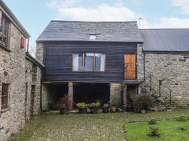 A building with a wooden upper level and potted plants at Swallows Nest Widecombe-in-the-Moor near Postbridge