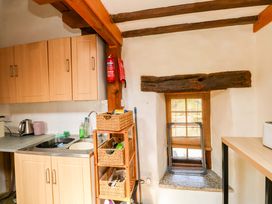 A kitchen with cabinets, sink, and window at Swallows Nest Widecombe-in-the-Moor near Postbridge