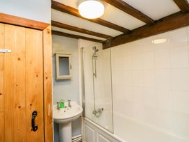 A bathroom with a bathtub, shower, and sink at Swallows Nest in Widecombe-in-the-Moor near Postbridge