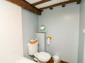 A bathroom with a toilet and mirror at Swallows Nest in Widecombe-in-the-Moor near Postbridge