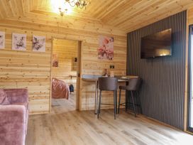 A living room with a sofa and bar stools at The Sty in Hatton, Derbyshire