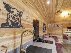 A kitchen with a sink and wall art at The Sty in Hatton, Derbyshire