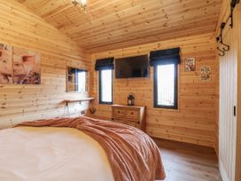A bedroom with wooden walls and a bed at The Sty in Hatton, Derbyshire