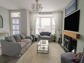 A living room with a sofa and coffee table at Bryn Y Mor in Beaumaris