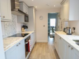 A kitchen with cabinets and appliances at Bryn Y Mor Beaumaris