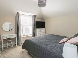 A bedroom with a bed, television, and a desk at Bryn Y Mor Beaumaris