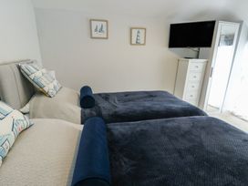 A bedroom with two single beds and a television at Bryn Y Mor Beaumaris