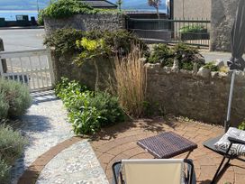 A garden area with a gate and seating at Bryn Y Mor in Beaumaris