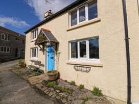 A house exterior with a blue door and a bench at 1 Mill Farm Cottages Narberth