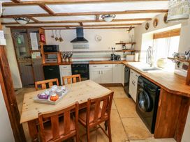 A kitchen with a dining table and appliances at 1 Mill Farm Cottages Narberth