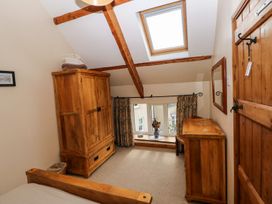 A bedroom with wooden furniture and a window at 1 Mill Farm Cottages Narberth
