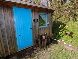 A wooden structure with a blue door and window at Mill Farm Cottages in Narberth