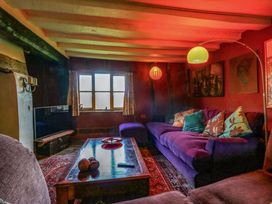 A living room with a purple sofa and television at Town Farm in 