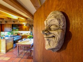 A kitchen with a wooden table and decorative mask at Town Farm 