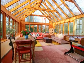 A conservatory with seating and plants at Town Farm in 