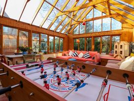 A conservatory with a foosball table and seating area at Town Farm